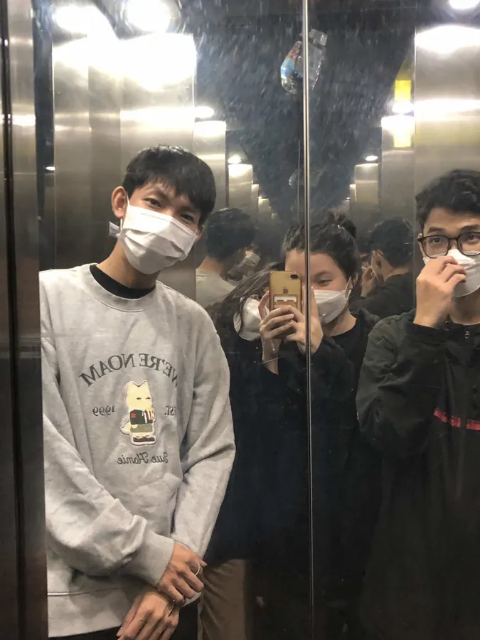 Friends taking a mirror selfie in an elevator